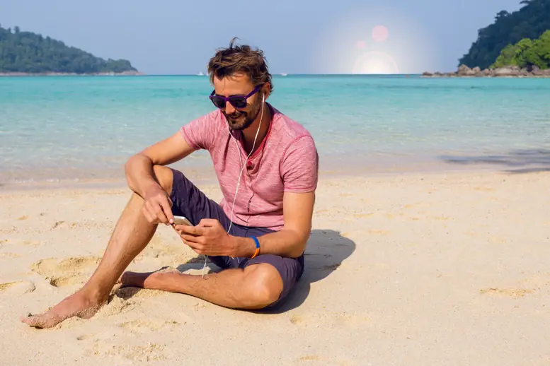hombre playa mirando movil