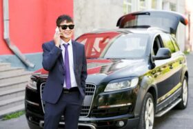 young-businessman-suit-sunglasses-talking-phone-next-to-expensive-car-outdoors-outside-68772535